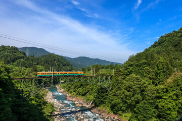 夏の千垣鉄橋を最徐行して通る富山地方鉄道