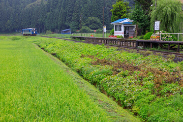 ボランティアによって手入れされた無人駅に秋田内陸線の気動車が到着する