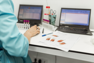 A scientist's hands are nimbly typing while immersed in groundbreaking medical research while working indoors in a bustling laboratory using a laptop computer.