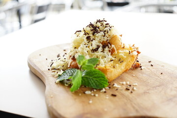 A close-up photo of a plate featuring a decadent fried banana dessert.