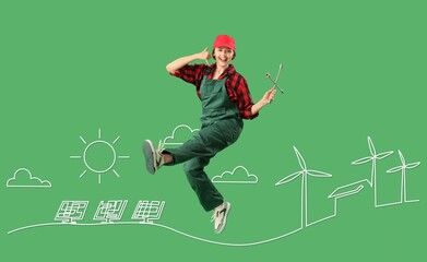 Fototapeta premium Jumping female engineer, drawn solar panels and windmills on green background