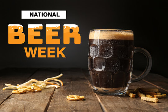 Mug of dark beer and snacks on table against black background