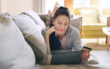 Woman, living room and happy on tablet with debit card on sofa for online shopping, payment and saving plan. Home, buying and smile on couch for internet banking, budget and investment or finance