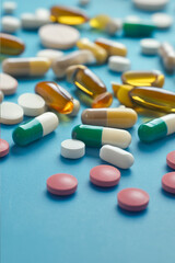 Assorted Colorful Pills and Capsules on Blue Background