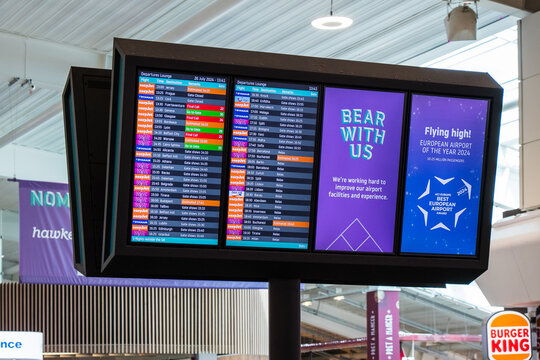London, UK - July 26, 2024: Flight boarding information screens at Luton airport terminal. London Luton Airport (LTN) is an international airport located in Luton, Bedfordshire, England.