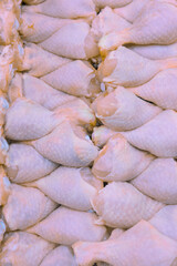 Fresh chicken thighs or legs placed on the counter of a butcher shop.