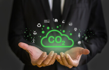 Concept of environmental sustainability and reducing carbon dioxide emissions, businessman hold...