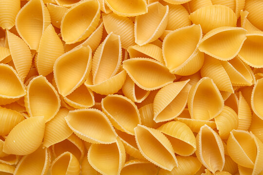 Raw conchiglie pasta as background - Powered by Adobe