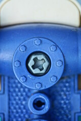 one gray bolt screwed into a piece of blue plastic toy