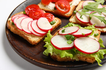 Plate with delicious radish bruschettas isolated on white background