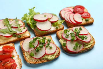Different radish bruschettas on blue background