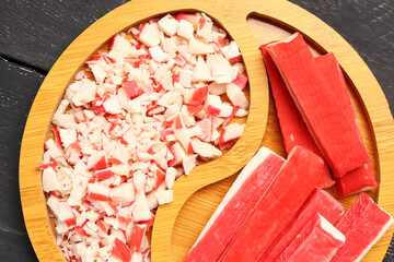 Plate with tasty crab sticks on dark wooden background, closeup © Pixel-Shot