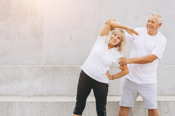 Senior Couple Exercising Together Outdoors, Stretching and Staying Active