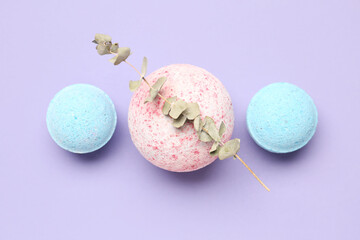 Bath bombs with eucalyptus branch on lilac background