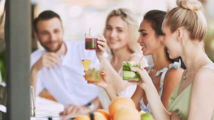 bar vibes. Happy,smiling young people, man and woman enjoying refreshing drinks, delicious cocktail in modern outdoor bar. Cheers. Concept of friendship, party, leisure, celebration, relaxation
