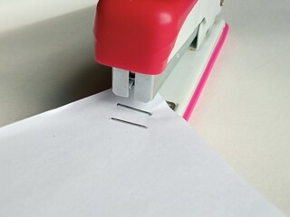 A stapler staples together sheets of paper and documents. The concept of paperwork, conclusion of...