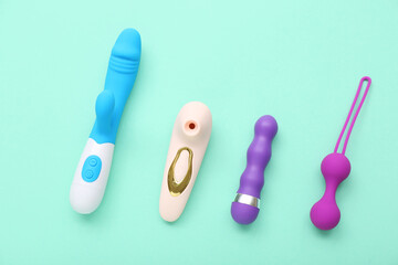 Vibrators with anal plug on turquoise background