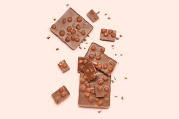 Sweet tasty chocolate with nuts on  light pink background