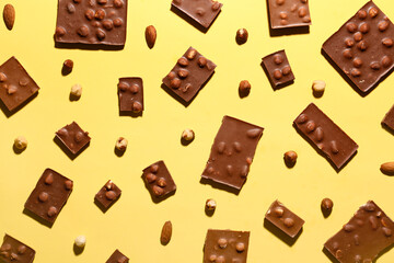 Sweet tasty chocolate with nuts on  yellow background