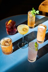 Assortment of cocktails with the sun on a blue table