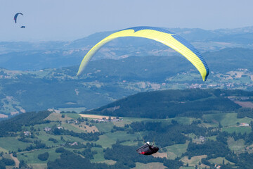 Sestola, Italy - 07 27 2024: Paraglider flies in the air. Aerial view of paragliding. Paraglider...