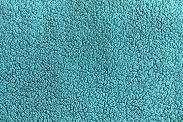abstract background of turquoise plaid of artificial fur on a knitted basis close up