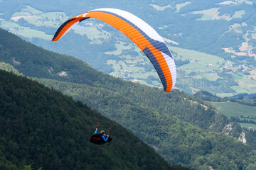 Sestola, Italy - 07 27 2024: Paraglider flies in the air. Aerial view of paragliding. Paraglider...