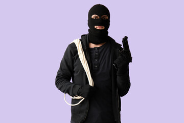 Male thief with rope and gun on lilac background © Pixel-Shot