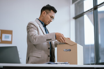 Concept businessman failure and unemployment problem, stress businessman packing up in office.