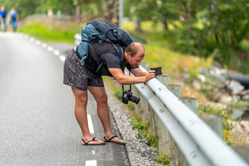 Fototapeta premium a male drone operator photographer at work in Andalsnes Norway. Man photographing the beauty of the fjord