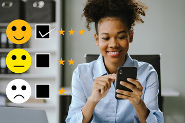 Happy African woman holding a digital tablet and smartphone with checkboxes rating smiley faces...