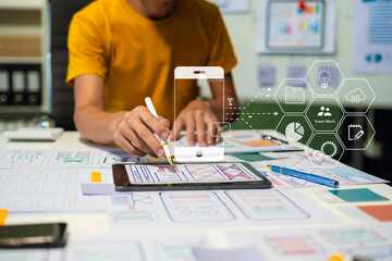 Creative male web designer planning application development for web mobile phone at modern...