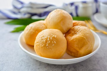 mini bun in a white plate with fork on cement background
