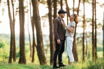 Looking at each other. Lovely couple are together in the forest at summer daytime