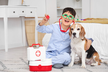 Funny little doctor with Beagle dog and toy stethoscope in bedroom