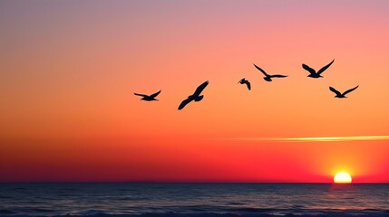 Fototapeta premium A stunning sunset over the ocean with birds flying gracefully in the sky, creating a peaceful and serene atmosphere.