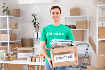 Male volunteer holding donation box with clothes in center