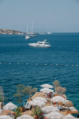 A scenic view of luxurious marine boats and yachts anchored by the coastline, displaying the...