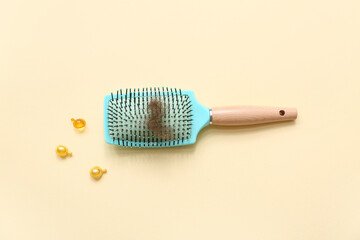 Brush, capsules and hair clump on beige background