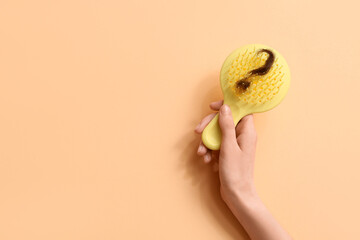 Hand with brush and clump of hair in shape of question mark on beige background. Hair loss concept