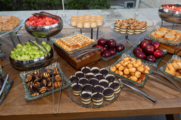 Buffet table with an assortment of fresh fruits and kosher for Passover baked goods.