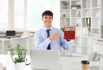 Male accountant pointing at calculator at workplace in office