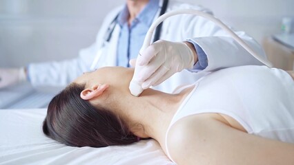 Naklejka premium Doctor man is using ultrasound equipment on neck of female patient lying down for a medical examination. Medicine and science