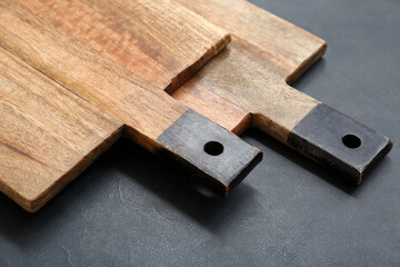 Wooden cutting boards on black background, closeup