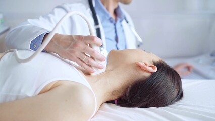 Obraz premium Doctor man is using ultrasound equipment on neck of female patient lying down for a medical examination. Medicine and science