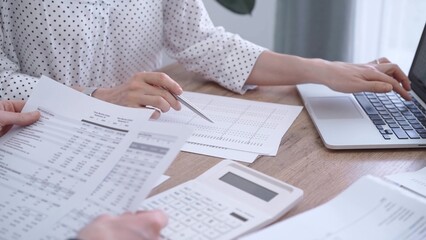 Bookkeeper woman is working with a colleague, using magnificent glass, calculator and laptop. Audit...