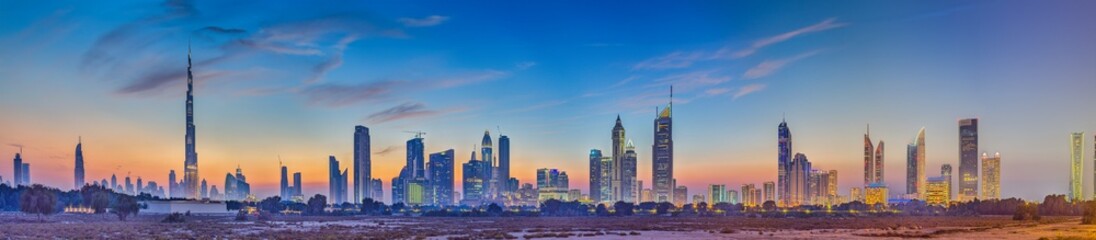 Panoramic image of the illuminated skyline of Dubai at dusk after sunset