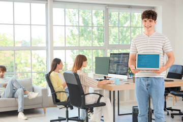 Male programmer with laptop in office