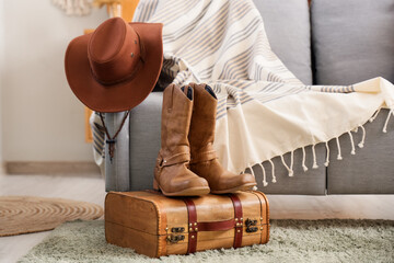 Cowboy hat on sofa with boots and bag in living room
