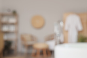 Blurred view of bathroom with shelf unit, armchairs and folding screen